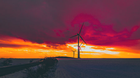 windmills in a snowy field at sunset