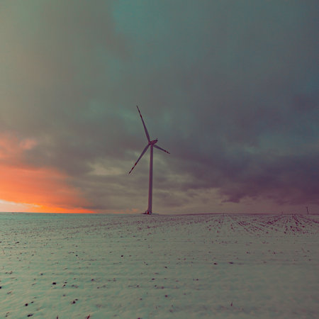windmill in a snowy field with a cloudy sky in the background