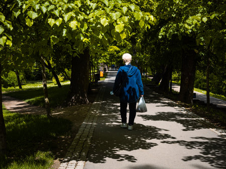woman in blue clothes in a green city parkの写真素材