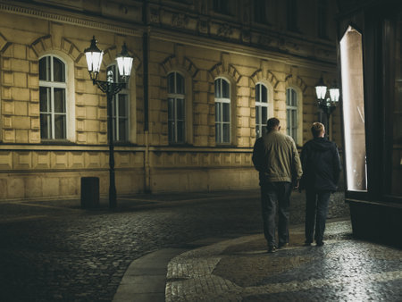 two men walking in the old town at nightの写真素材