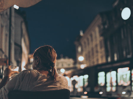 older woman in street cafe at nightの写真素材