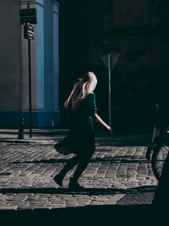woman with blonde hair on a cobblestone streetの写真素材