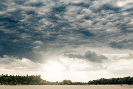 Stormy clouds over beach and Vistula river near from Warsaw, Poland.の写真素材