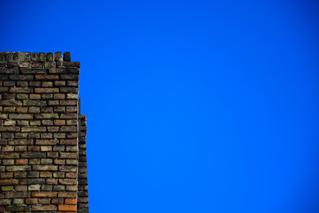 Old brick wall on a background of blue skyの写真素材