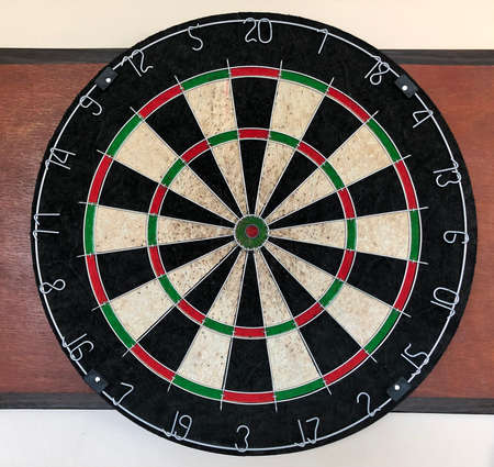 Dartboard with red and green arrows on the wall of the room