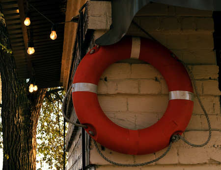 Life buoy on the wall at the pier. The building is decorated with vintage light bulbs.の写真素材