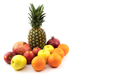 Beautiful fruits on a white isolated background. Pineapple, pomegranate, apples, oranges. Summer...