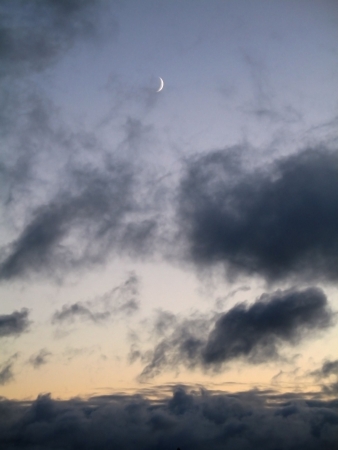 The new moon has appeared  But the sun has not sat down yet  Still a sunset  In the bottom part of a shot a pillow of clouds  The Background - the scattered cloudsの写真素材