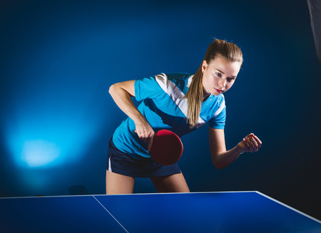 Portrait Of Young Woman Playing Table Tennis On Black Background with lightsの写真素材