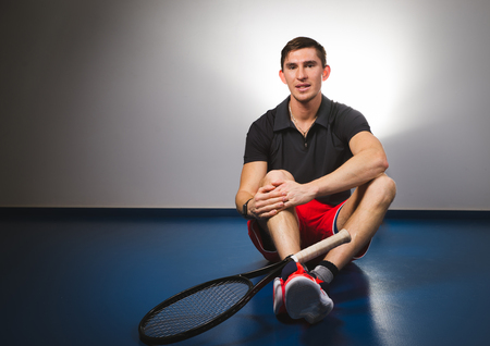 Guy changing the grip of his racketの写真素材