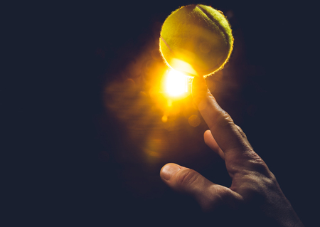 hand on a white background squeezes a tennis ballの写真素材