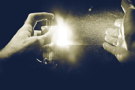 spray perfume on men body black backgroundの写真素材
