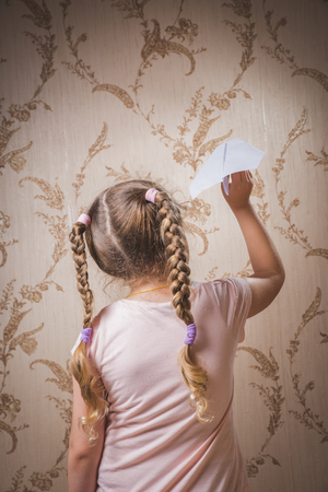 a man throwing a paper airplane/planes with right hand on bright sky with cloud backgroundの写真素材