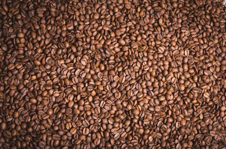 High resolution top view close up macro photo of look delicious dark roasted coffee beans, Flash light reflecting on the surface of the coffee beans make it look shinny beautiful and be nice for eat.の写真素材