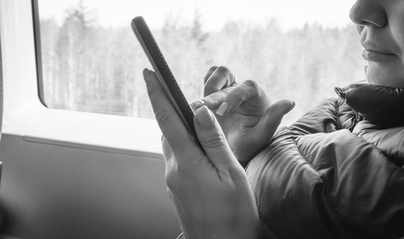 Young girl works on the smartphone on the internet and goes to the trainの写真素材