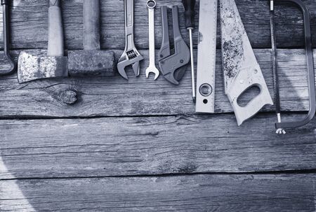 Dirty set of hand tools on a wooden panelの写真素材