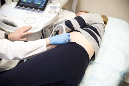 Female doctor does ultrasound for a pregnant woman in the hospital.