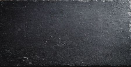 Empty Slate - Black serving platter on a wooden table outdoors.の写真素材