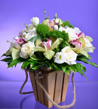 Close up flower bouquet arrangement in wicker basket isolated on white, carnation, rose, orchid, anunculusの写真素材