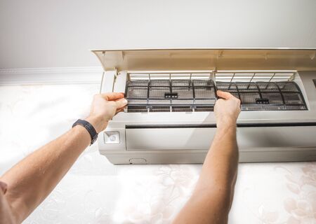 Close-up outdoor air condition unit with clogged obstructed compressor radiator grill.の写真素材