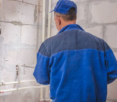real photo of installation of the conditioner, the worker drills a hole in a wallの写真素材