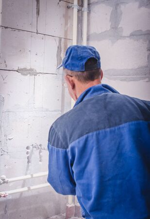 Man holding plugger against the brick wallの写真素材