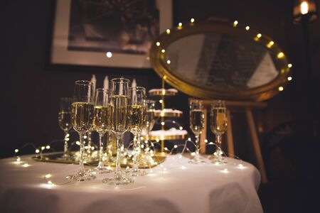 Two glasses of champagne with lights in the background. very shallow depth of field, focus on near glass.の写真素材