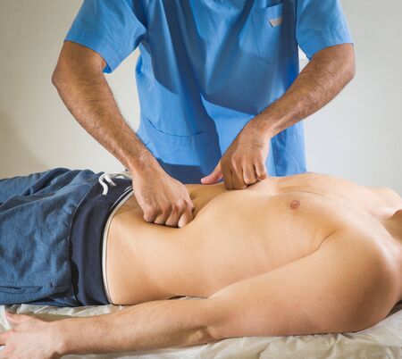 masseur makes anti-cellulite massage young woman isolated on white backgroundの写真素材