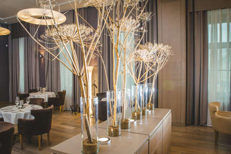 Valencia, Spain - March 19, 2019: Flowers decorating the centerpieces with luxury cutlery on the tables of a wedding hall.のeditorial素材