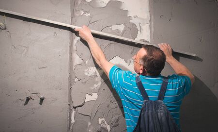 Man's hand plastering a wall with trowel.の写真素材