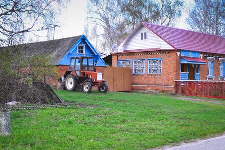 Old rusty blue tractor in a wood. Russian villageの写真素材