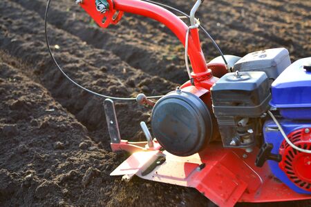farmer in a field with rototiller , tiller tractorの写真素材