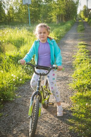 teenage girl on a bicycle with hand upの写真素材