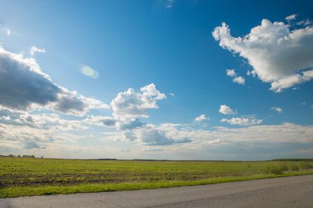 Green Grass Field Landscape with fantastic clouds in the backgroundの写真素材