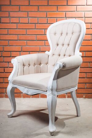 Antique armchair furniture with cushion against white wallの写真素材