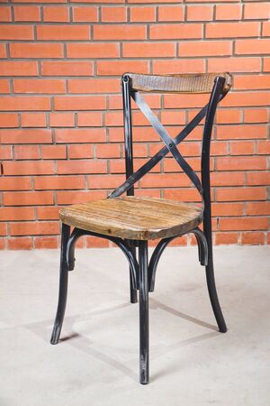 Vintage old black wooden chair in grungy interior. Loneliness, estrangement, alienation concept.の写真素材
