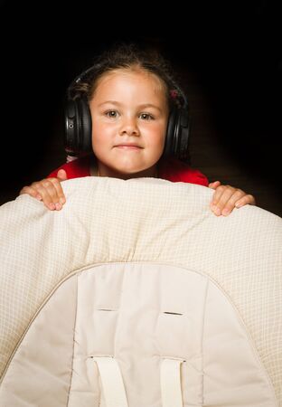 home, technology and music concept - little girl with headphones at homeの写真素材
