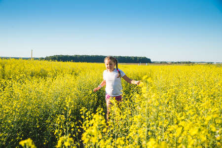 Cute happy child runs across the field of wheatの写真素材