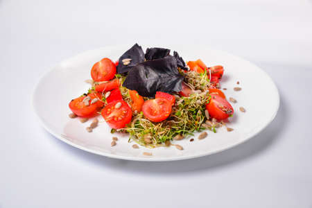 Arugula sprouts cut for salad in a wooden plate on the old rustic table. Micro greens full of vitamins and freshnessの写真素材