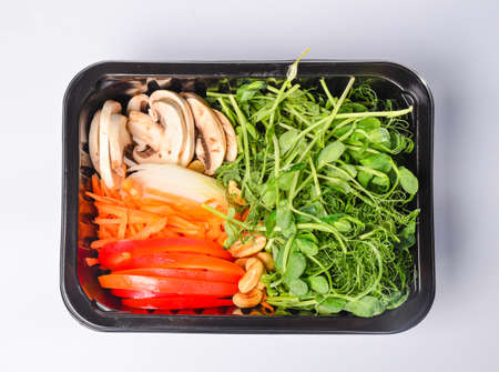 Arugula sprouts cut for salad in a wooden plate on the old rustic table. Micro greens full of vitamins and freshnessの写真素材