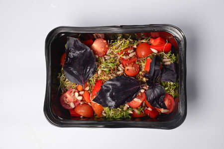 Arugula sprouts cut for salad in a wooden plate on the old rustic table. Micro greens full of vitamins and freshnessの写真素材