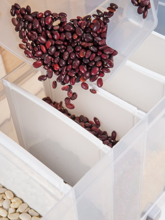 A large selection of bulk dry foods in clever dispensers and a weighing scale at an upscale grocery storeの写真素材