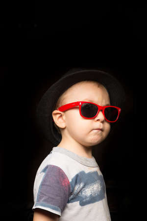 fashionable kid in summer park. fashion kid with glassesの写真素材