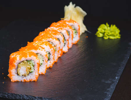 Traditional delicious fresh sushi roll set on a black background with reflection. Sushi roll with rice, cream cheese, red fish, salmon. Sushi menu. Japanese kitchen, restaurant. Seafood, asian foodの写真素材