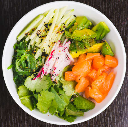 Salmon Salad with spinach, cherry tomatoes, corn salad, baby spinach, fresh mint and basil. Home made food. Concept for a tasty and healthy meal. dark stone background. top view. close up.の写真素材