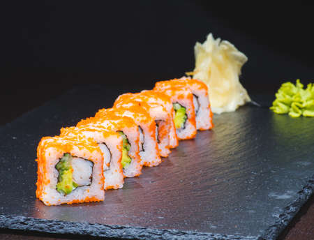 Traditional delicious fresh sushi roll set on a black background with reflection. Sushi roll with rice, cream cheese, red fish, salmon. Sushi menu. Japanese kitchen, restaurant. Seafood, asian foodの写真素材