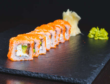 Traditional delicious fresh sushi roll set on a black background with reflection. Sushi roll with rice, cream cheese, red fish, salmon. Sushi menu. Japanese kitchen, restaurant. Seafood, asian foodの写真素材