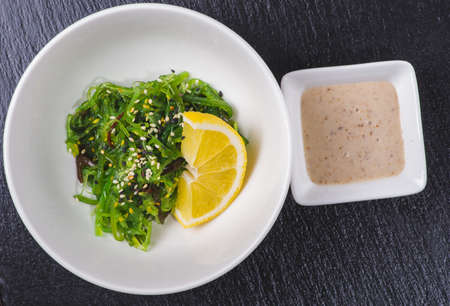 Bowl with tasty seaweed salad on tableの写真素材