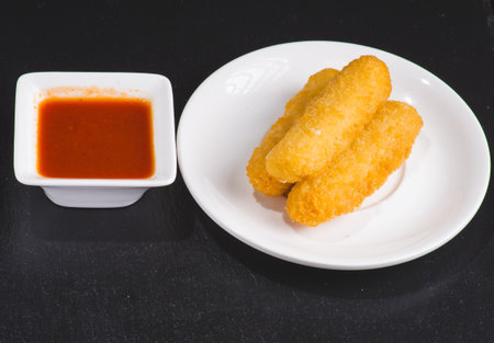 Cheese sticks and sauce on board, closeupの写真素材