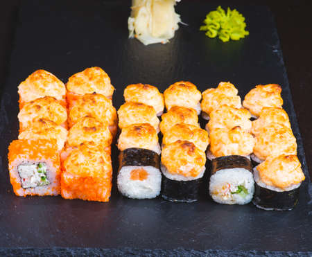 Delicious asian food, roll, sushi and gunkan set. Traditional japanese cuisine restaurant menu assortment. Oriental culinary, eastern cooking. Tasty appetizers on wooden platter and chopsticksの写真素材